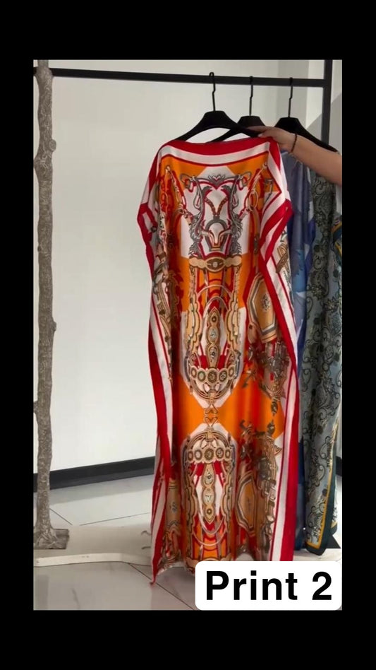 Vibrant multi-colored circular print kaftan with a bright orange border, displayed on a clothing rack 02