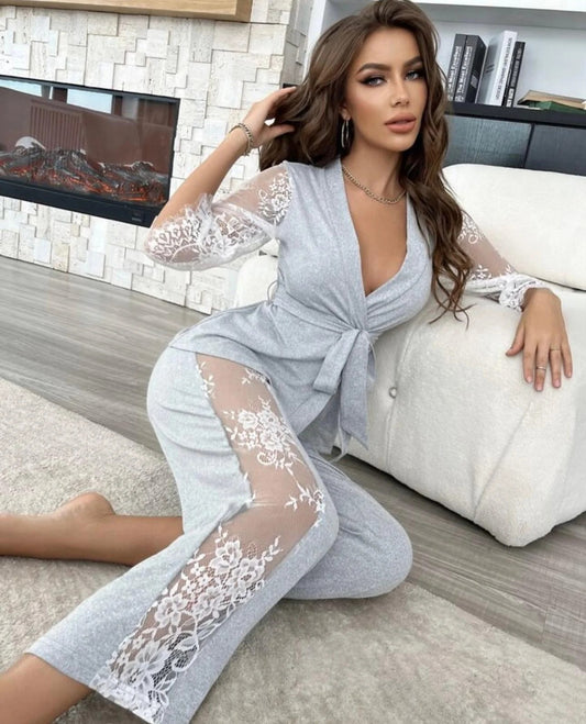 seductive Woman wearing a light gray lace robe sitting on a couch in a cozy living room.
