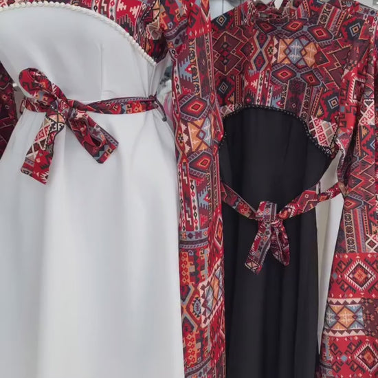 Long black dress with a red and blue geometric pattern on the bodice and wide sleeves, featuring a matching waist belt tied in a bow 04